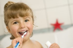 Kid brushing her teeth