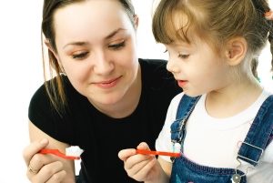Mother and daughter brushing together