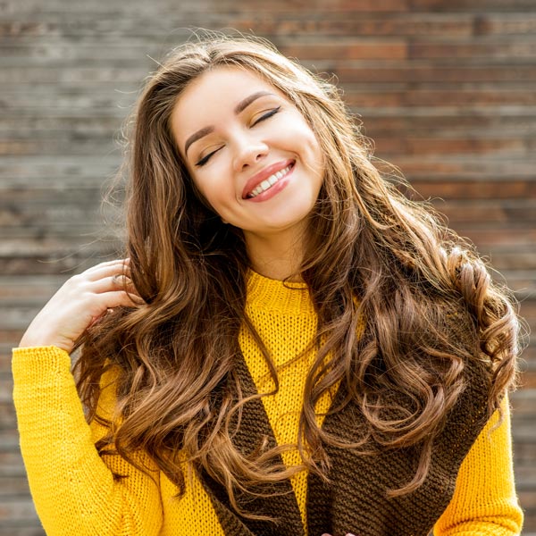 woman in yellow sweater smiling