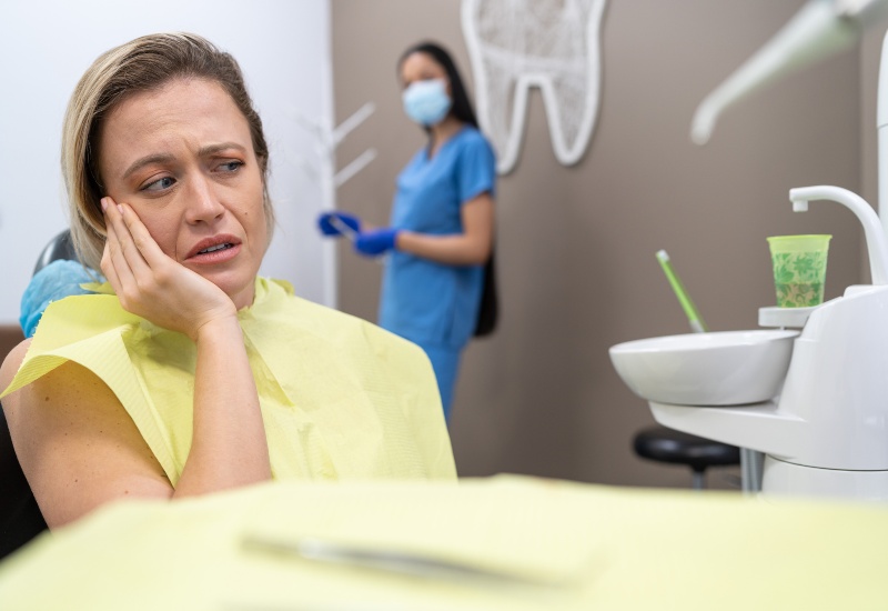 Worried woman with tooth pain in dental clinic, in St. Charles & Glen Ellyn, IL.