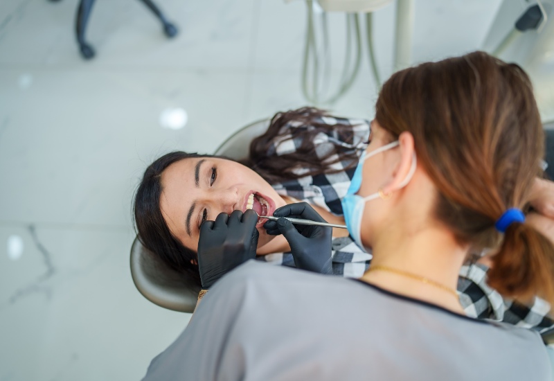 Dentist placing implant while talking with patient in St. Charles & Glen Ellyn, IL