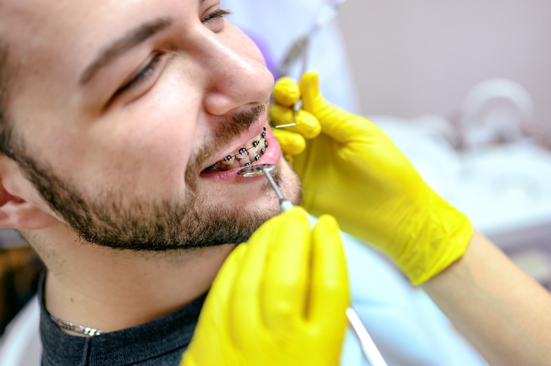 A smiling patient with braces is examined by a dentist in St. Charles & Glen Ellyn, IL