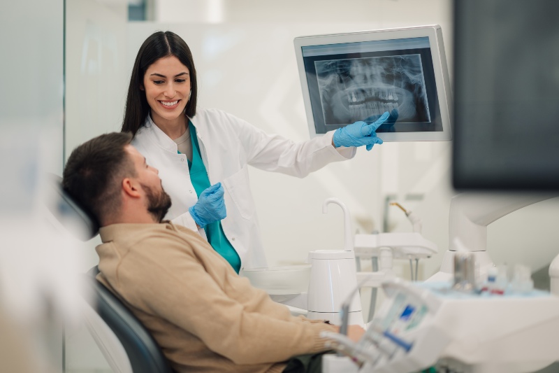 Female dentist showing a teeth x-ray to a male patient in St. Charles & Glen Ellyn, IL