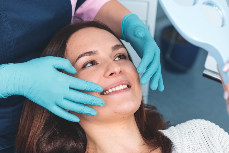 Dentist assessing smile symmetry during cosmetic exam in St. Charles and Glen Ellyn, IL