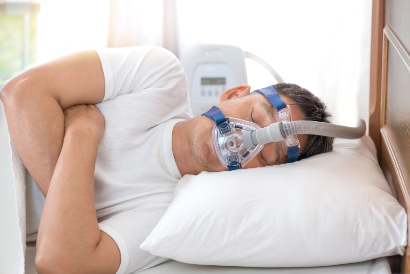 Person sleeping with a CPAP mask for sleep apnea therapy in St. Charles and Glen Ellyn, IL